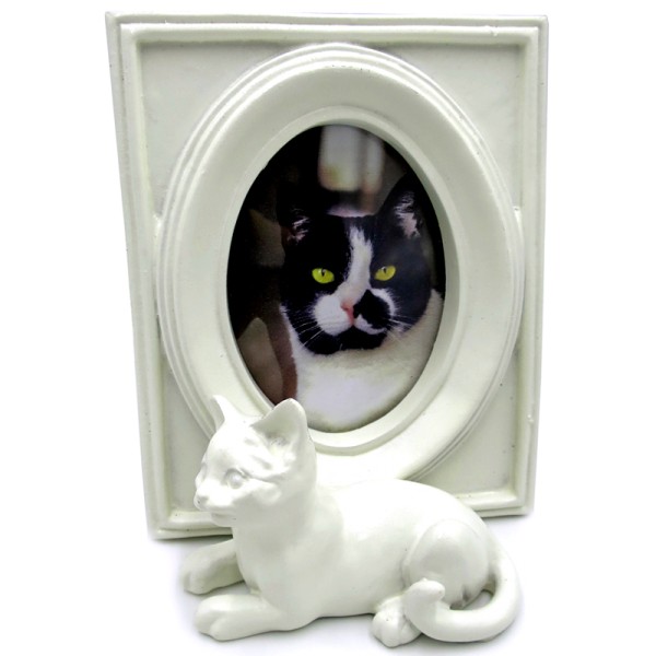 A cat photo frame in a white vintage frame with a cat figurine.