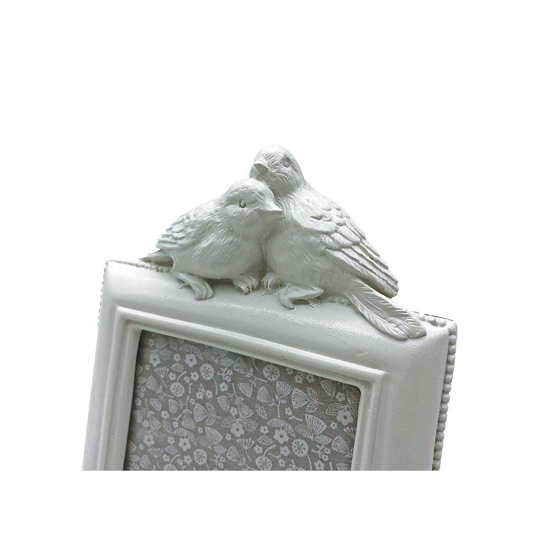 Close up of decorative birds on top of a white photo frame.