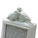 Close up of decorative birds on top of a white photo frame.