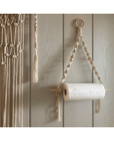 Macramé paper towel holder handcrafted from cream cotton, hanging on a light-coloured wood wall. Macramé paper towel holder handcrafted from cream cotton, hanging on a light-coloured wood wall.
