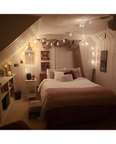 A bohemian styled bedroom with string lights, a plush bed and a hanging macramé vintage lampshade. A bohemian styled bedroom with string lights, a plush bed and a hanging macramé vintage lampshade.