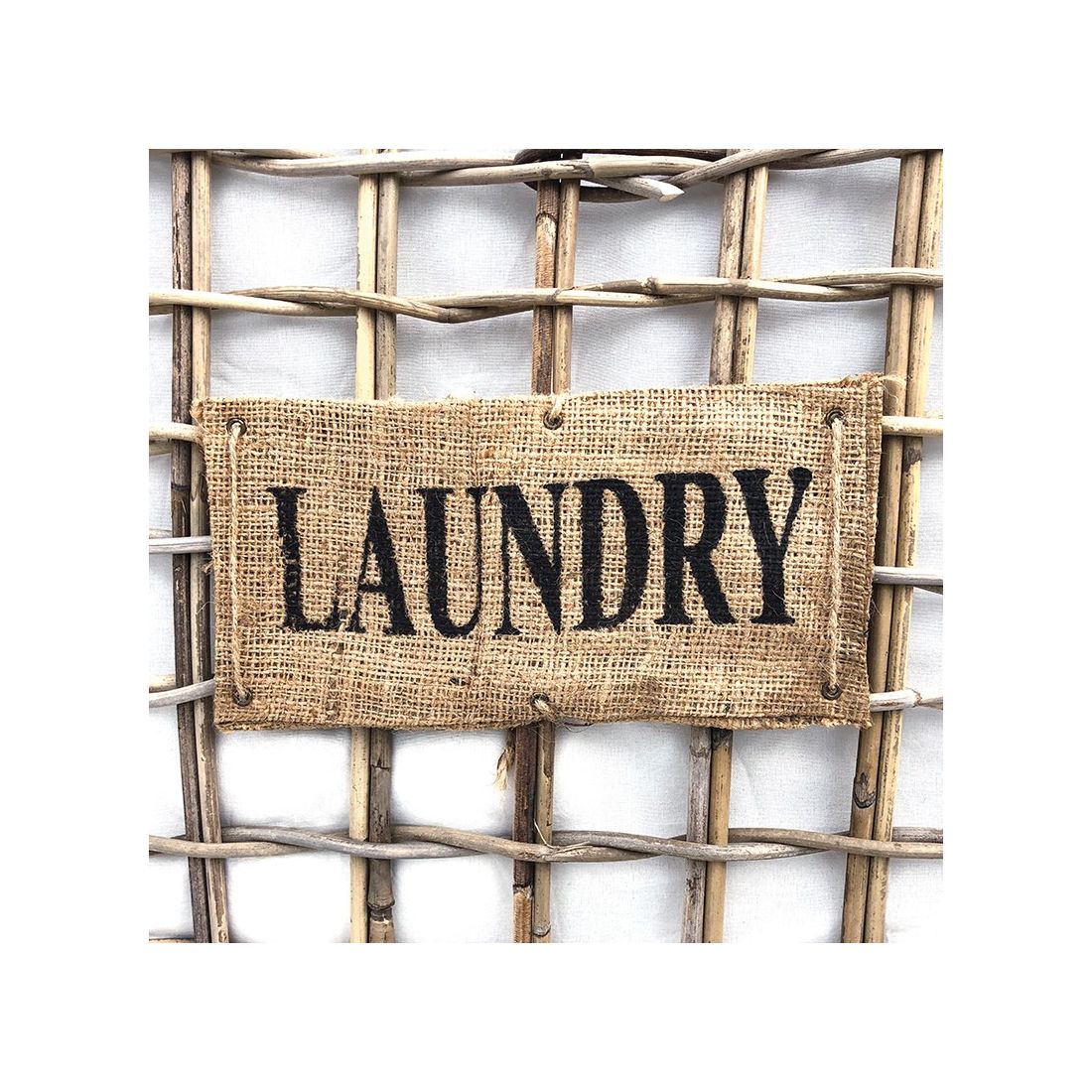 De rotan wasmand op wielen bevat een geweven bordje met laundry. De rotan wasmand op wielen bevat een geweven bordje met laundry.