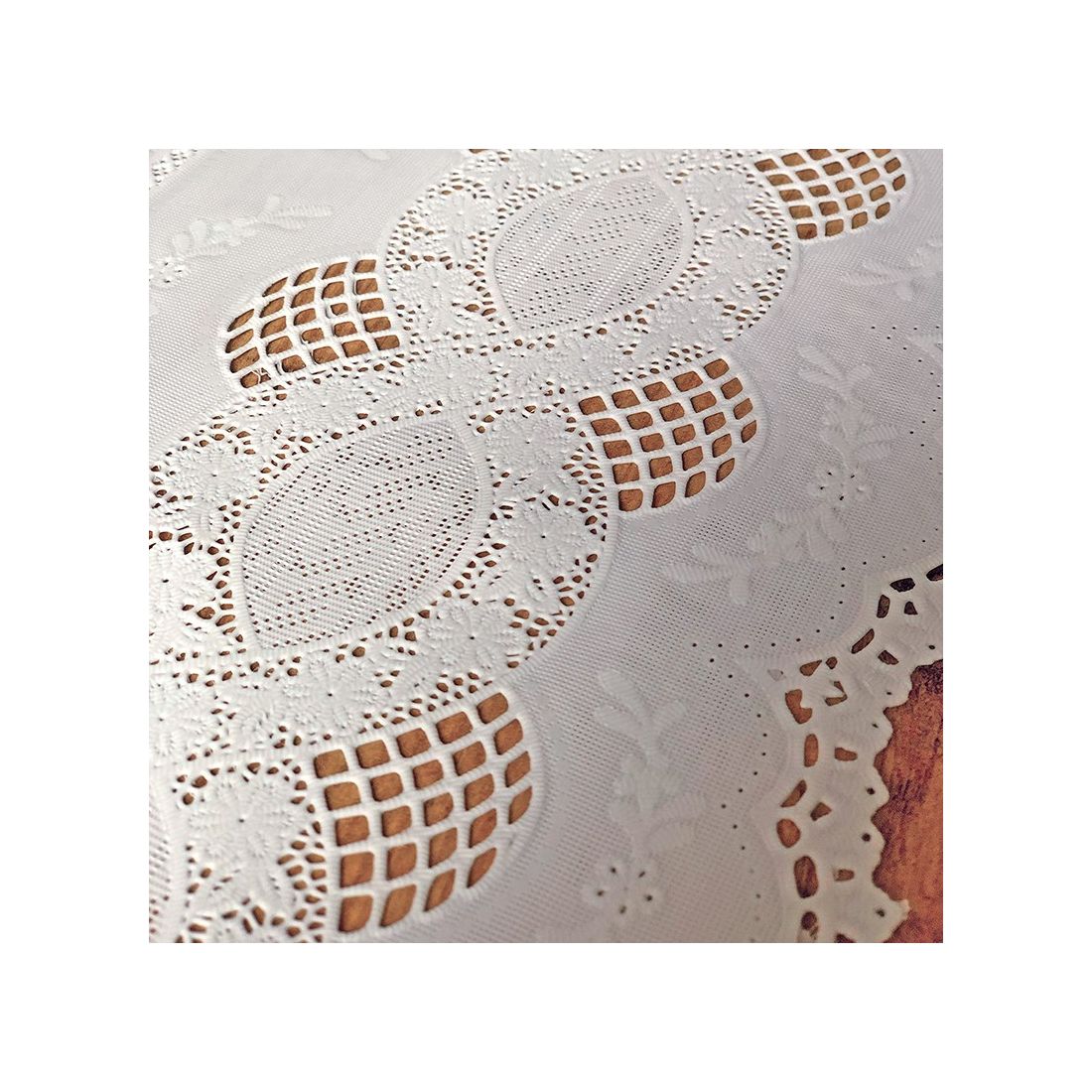 Close up detail of a white table runner made from vinyl with lace details.