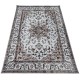 An ornate beige area rug patterned with a detailed border and central medallion design.