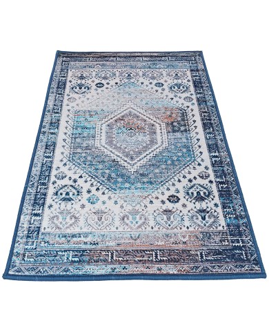 Traditional blue area rug in shades of blue and white and a central diamond motif.