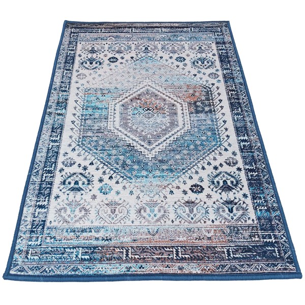 Traditional blue area rug in shades of blue and white and a central diamond motif.