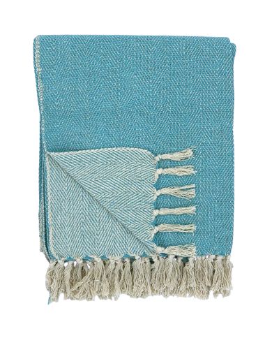 A folded blue throw blanket with a herringbone pattern and white tassels.