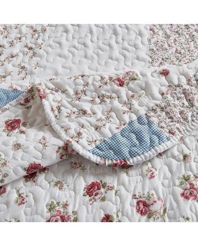 Close-up van een bed sprei bloemen motief met een kleine rozenprint en een verfijnde stikstructuur. Close-up van een bed sprei bloemen motief met een kleine rozenprint en een verfijnde stikstructuur.