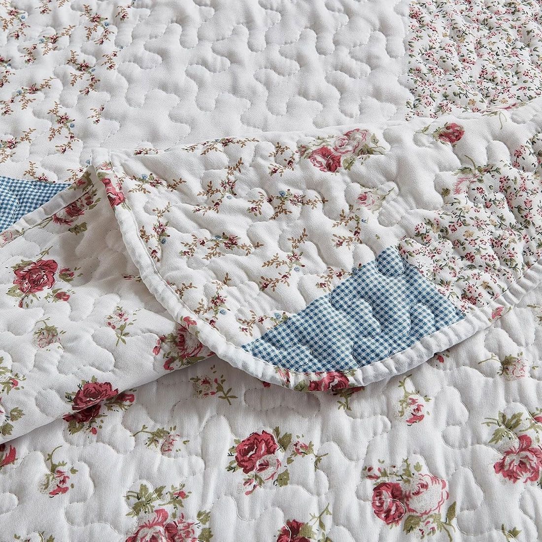 Close-up of a floral quilt, showcasing a small rose print with a delicate stitching texture.