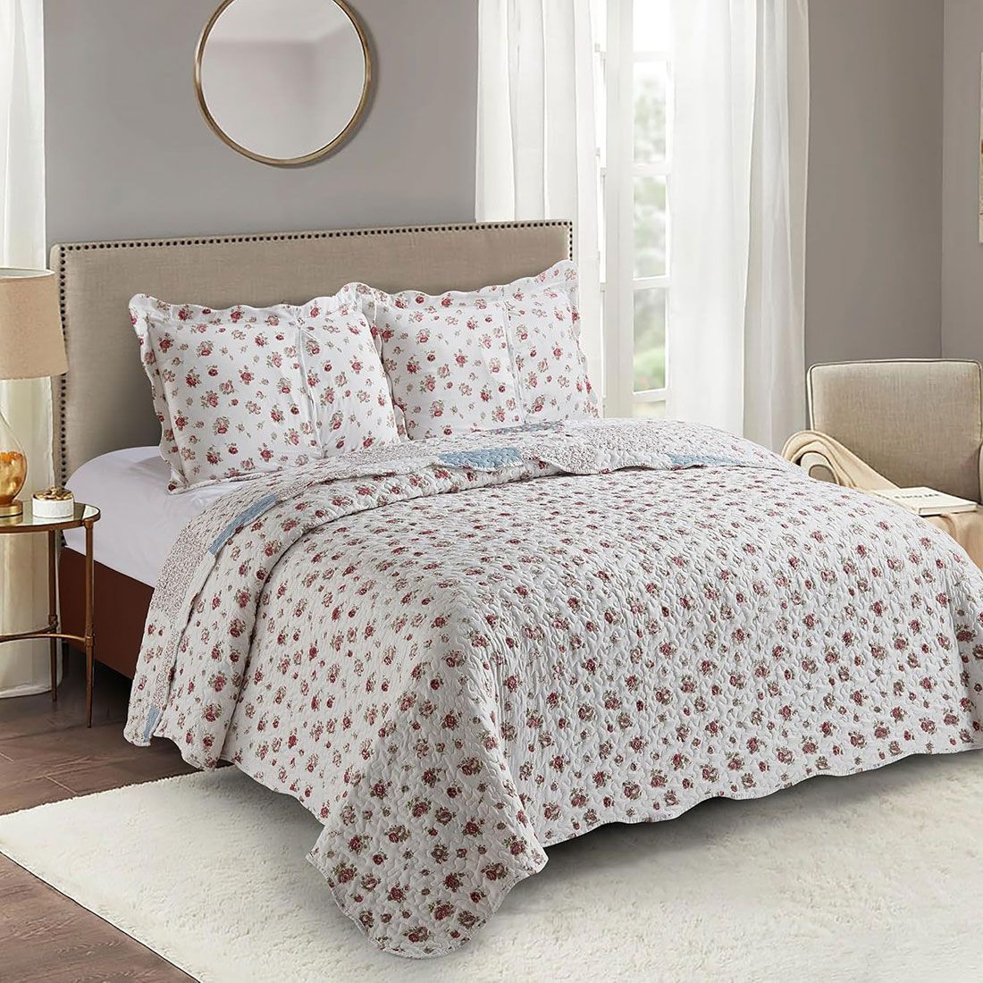 Showcasing the reverse design of a floral quilt, a small rose print, paired with matching pillows on a neatly made bed.