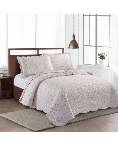 Het omgekeerde ontwerp van een bedsprei oud roze met delicate rozenknoppen op een crèmekleurige achtergrond.