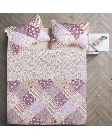 Top view of a patchwork quilt on a bed, complemented by matching decorative pillows. Top view of a patchwork quilt on a bed, complemented by matching decorative pillows.