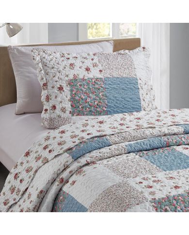 Een kussensloop blauw met bijpassende sprei op een knus bed bij het raam. Een kussensloop blauw met bijpassende sprei op een knus bed bij het raam.