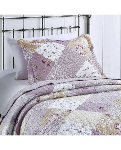 A floral pillowcase with matching bedspread on a cosy metal bed. A floral pillowcase with matching bedspread on a cosy metal bed.