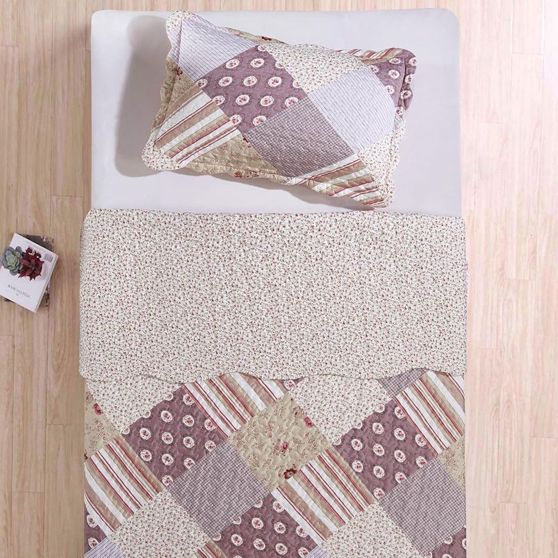 Top view of a pink patchwork pillowcase on a bed, complemented by a matching patchwork quilt.