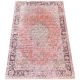 Vintage rug with a distressed pattern in shades of orange and beige.