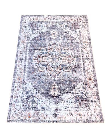 A vintage-style grey rug with intricate patterns in shades of grey and hints of blue.