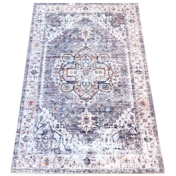 A vintage-style grey rug with intricate patterns in shades of grey and hints of blue.