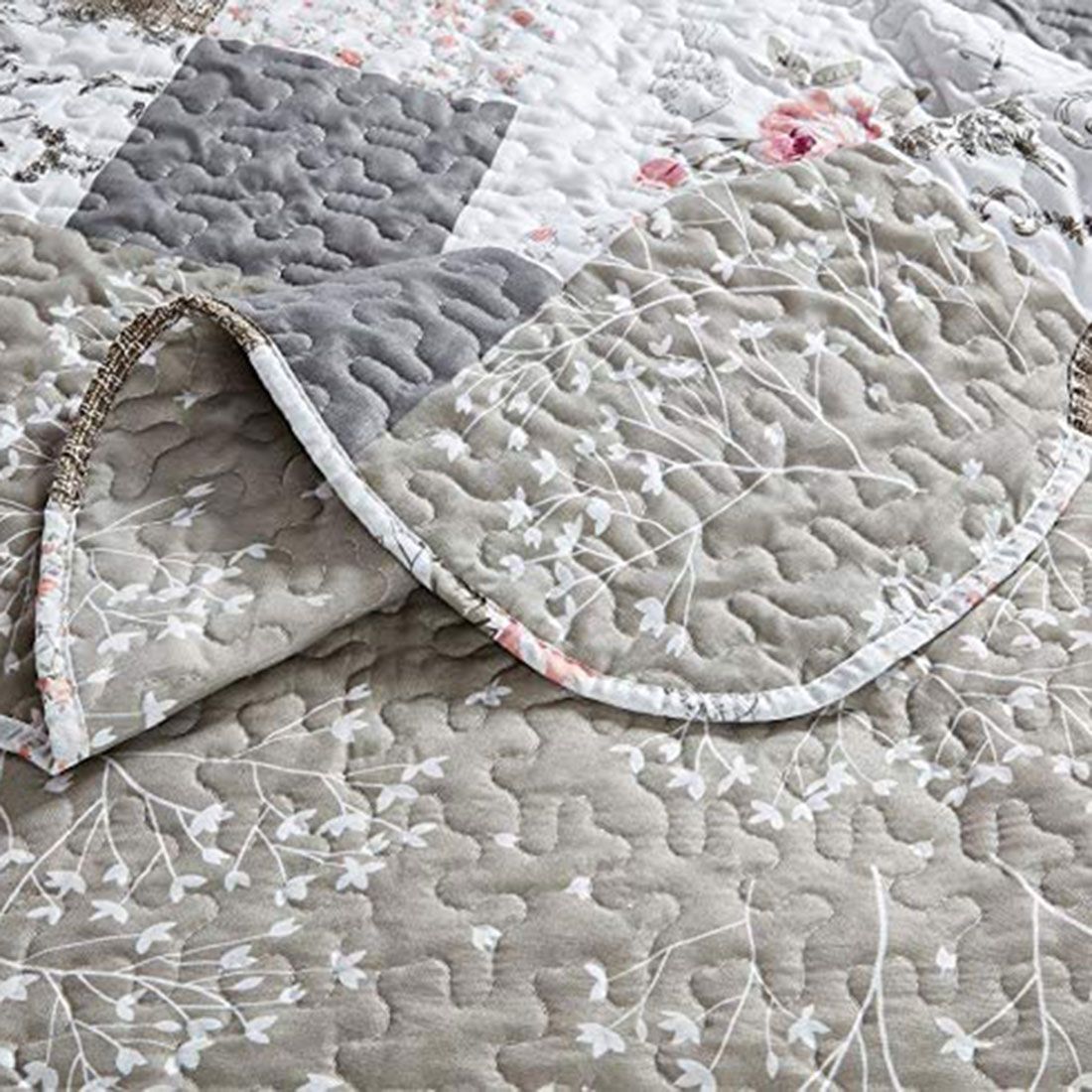 Close-up of a floral and patterned quilt in beige, showcasing soft beige and whites with a delicate stitching texture. Close-up of a floral and patterned quilt in beige, showcasing soft beige and whites with a delicate stitching texture.
