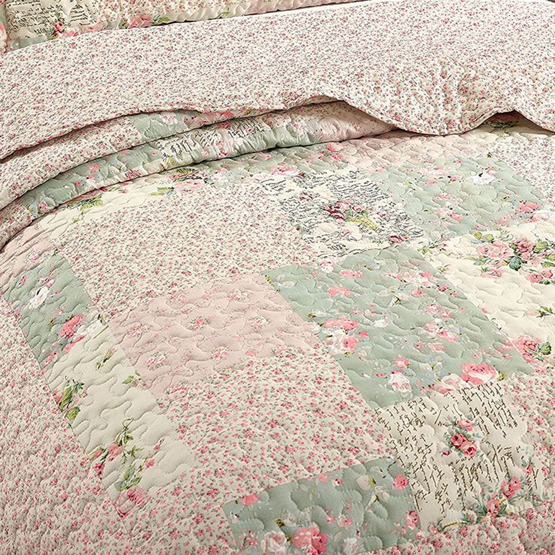 Close-up van een bedsprei bloemen motief, met roze en salie getint patchwork en fijne stikstructuur. Close-up van een bedsprei bloemen motief, met roze en salie getint patchwork en fijne stikstructuur.