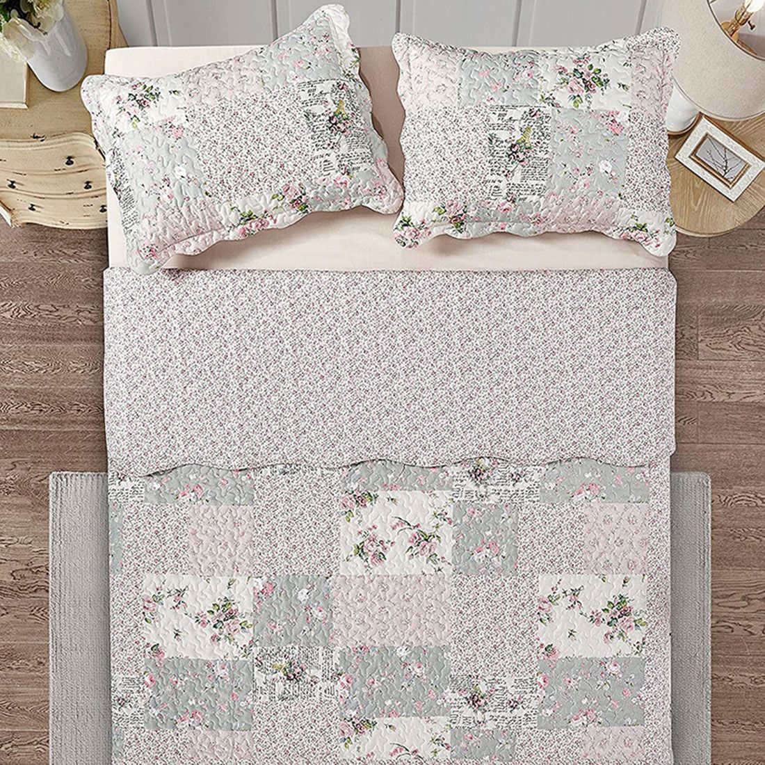 Bovenaanzicht van een bedsprei bloemen motief op een bed, aangevuld met bijpassende sierkussens. Bovenaanzicht van een bedsprei bloemen motief op een bed, aangevuld met bijpassende sierkussens.