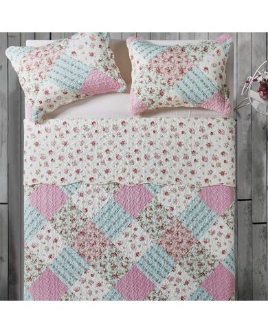 Top view of a patchwork pink quilt on a bed, complemented by matching decorative pillows. Top view of a patchwork pink quilt on a bed, complemented by matching decorative pillows.