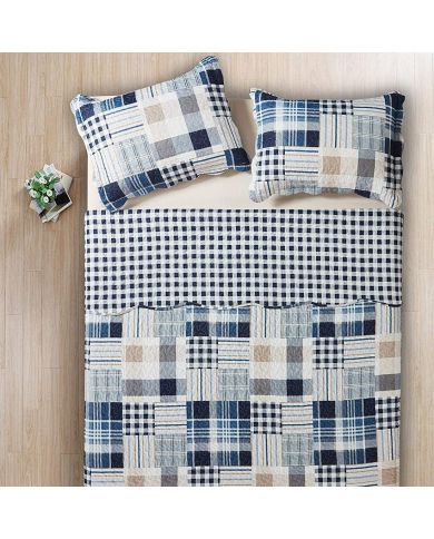 Top view of a blue patchwork quilt on a bed, complemented by matching decorative pillows. Top view of a blue patchwork quilt on a bed, complemented by matching decorative pillows.