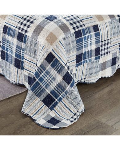 Detail of a blue quilt showcasing blue and white patchwork, vermicelli stitching and scalloped edging. Detail of a blue quilt showcasing blue and white patchwork, vermicelli stitching and scalloped edging.