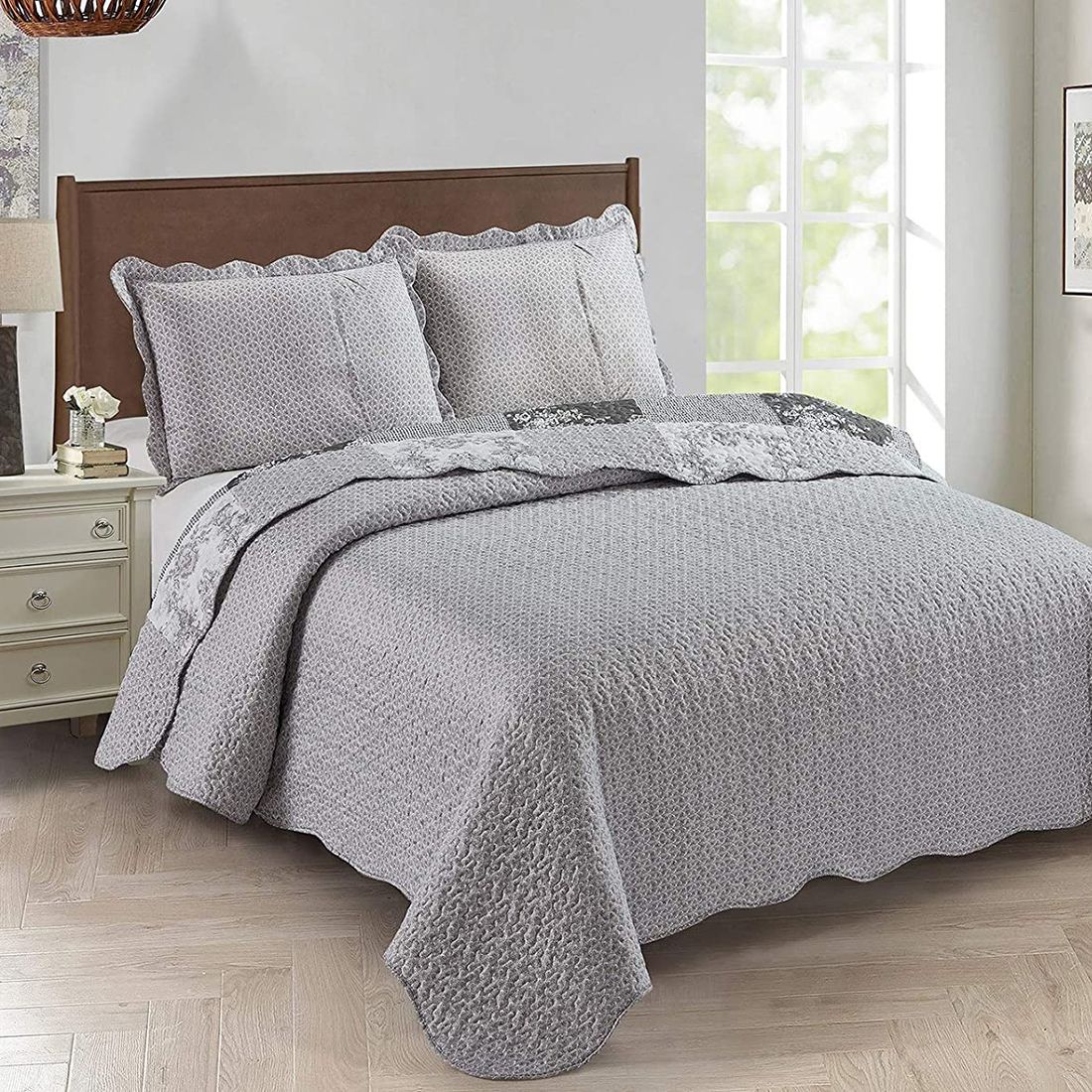 Showcasing the Toile de Jouy patchwork design of the grey quilt, paired with matching pillows. Showcasing the Toile de Jouy patchwork design of the grey quilt, paired with matching pillows.