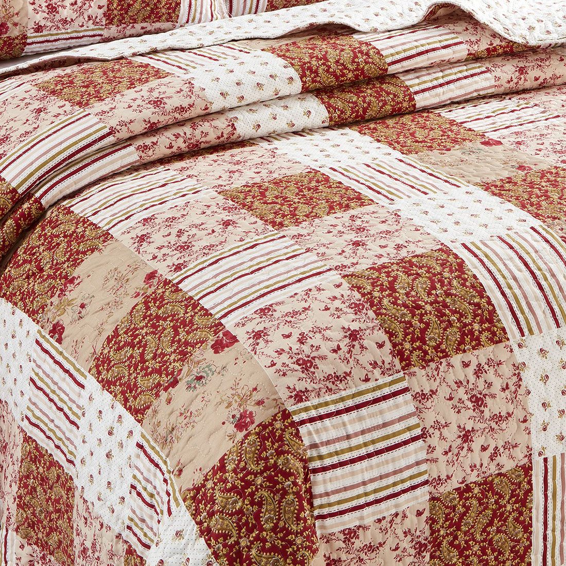 Close-up of a quilt, showcasing a symphony of muted pinks and cranberry tiles. Close-up of a quilt, showcasing a symphony of muted pinks and cranberry tiles.