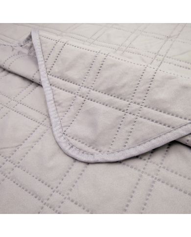 Close-up van een bedsprei grijs met een delicaat stikselpatroon. Close-up van een bedsprei grijs met een delicaat stikselpatroon.