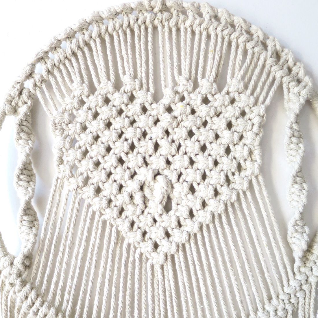 Details of the knot-work in the heart design of the macramé wall hanging.