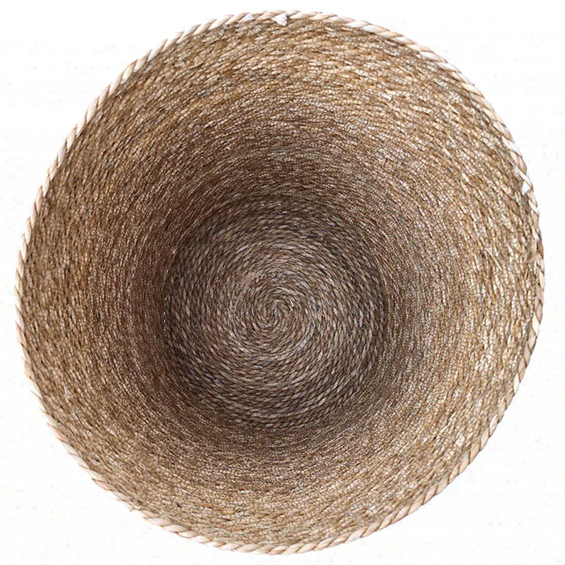 Een bovenaanzicht van een ronde, rieten wasmand met deksel in natuurlijke tinten.