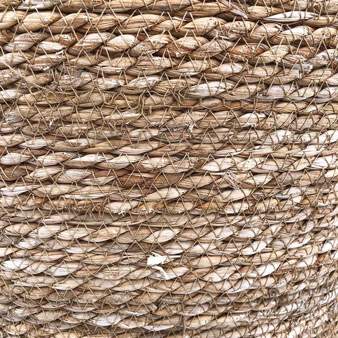 Close-up van een rieten wasmand met deksel, met geweven natuurlijke vezels.