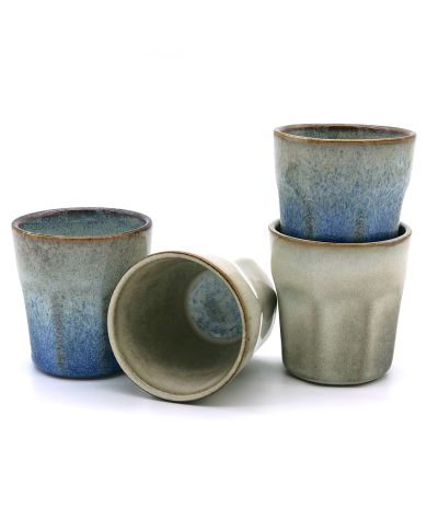 Four handmade espresso cups in varying shades of blue and grey, stacked and arranged artistically.