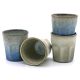 Four handmade espresso cups in varying shades of blue and grey, stacked and arranged artistically.