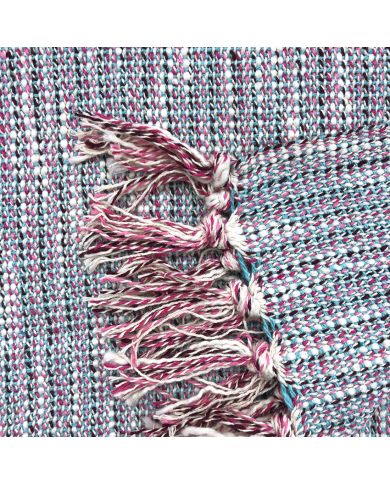 Close-up van een geweven katoenen plaid met kwastjes aan de randen. Close-up van een geweven katoenen plaid met kwastjes aan de randen.