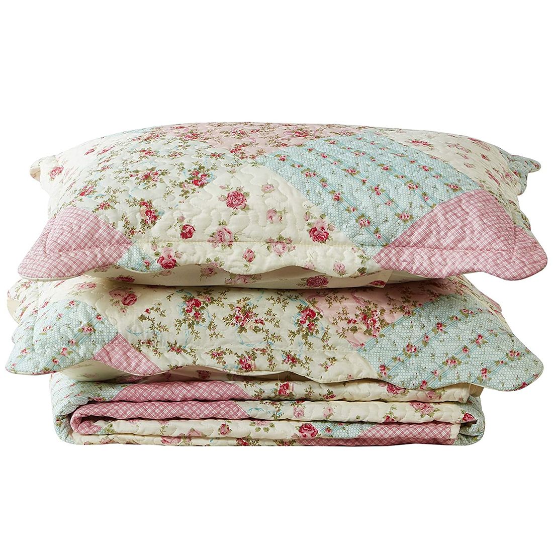 Gestapelde salie en roze kussensloop met patchwork en lentebloemmotieven.