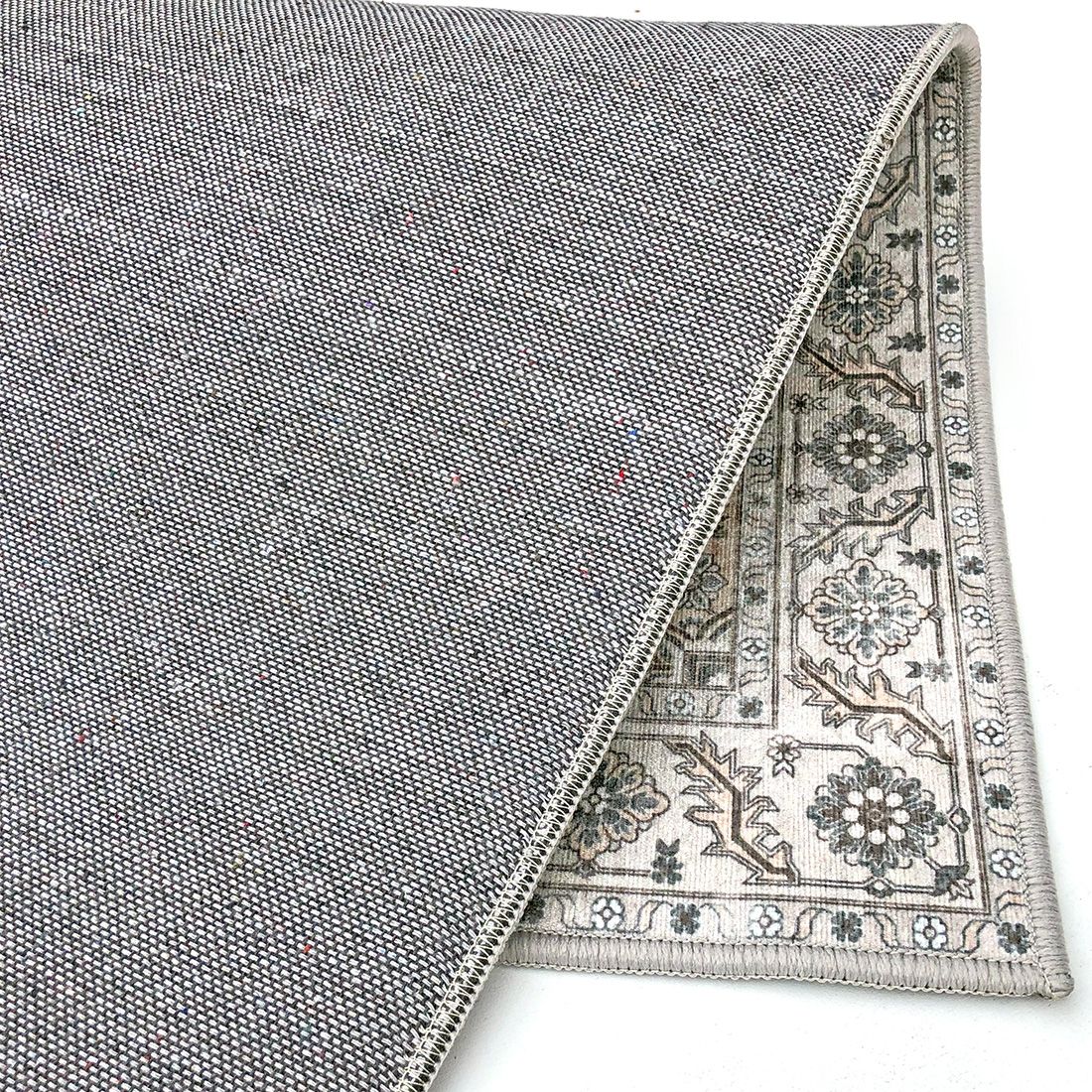 The reverse side of a grey carpet displaying a durable canvas.