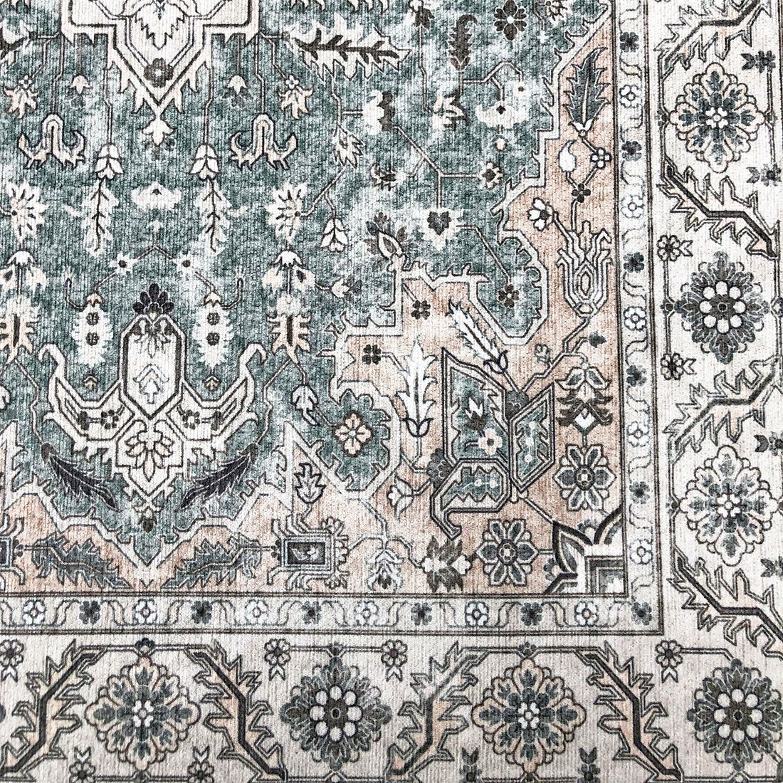 Close up of a Persian rug with intricate patterns in shades of grey and beige.