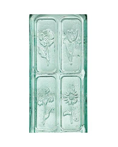 A close up of the floral engravings on the green-tinted glass oil bottle.