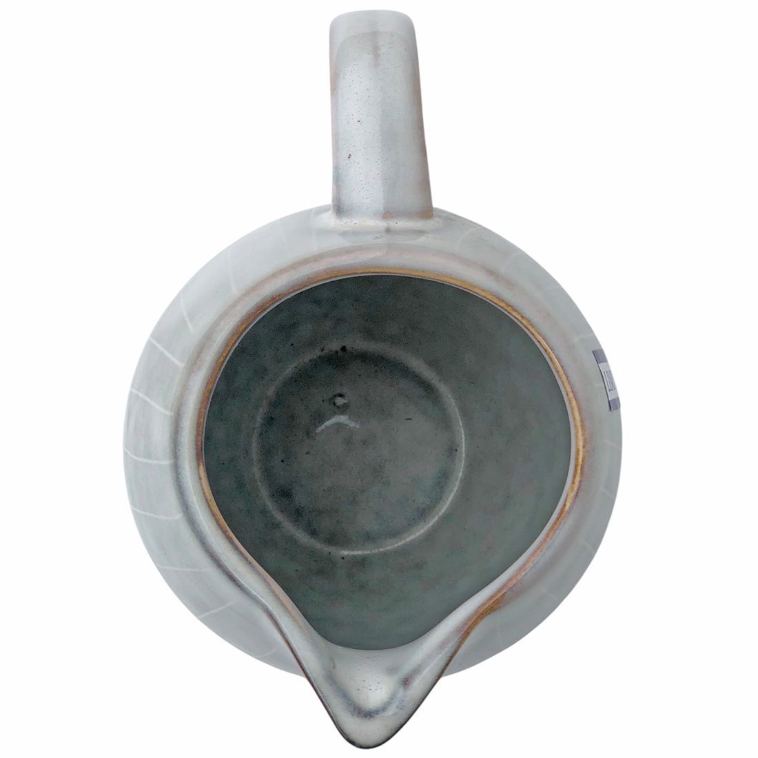 Close-up van de gebogen tuit van de keramische melkkan in Scandinavisch grijs.