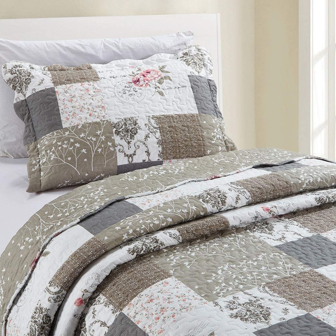 Een kussensloop beige met bijpassende sprei op een knus bed bij het raam.