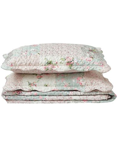 A stack of patchwork pillows featuring floral designs in soft pink and sage hues.