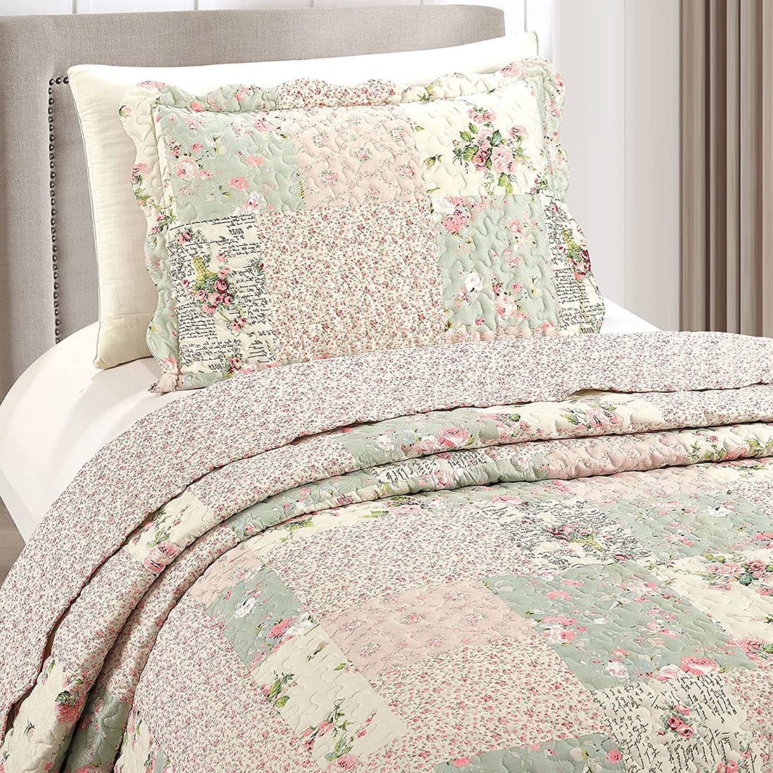 Een kussensloop groen en roze met bijpassende sprei op een knus bed bij het raam.