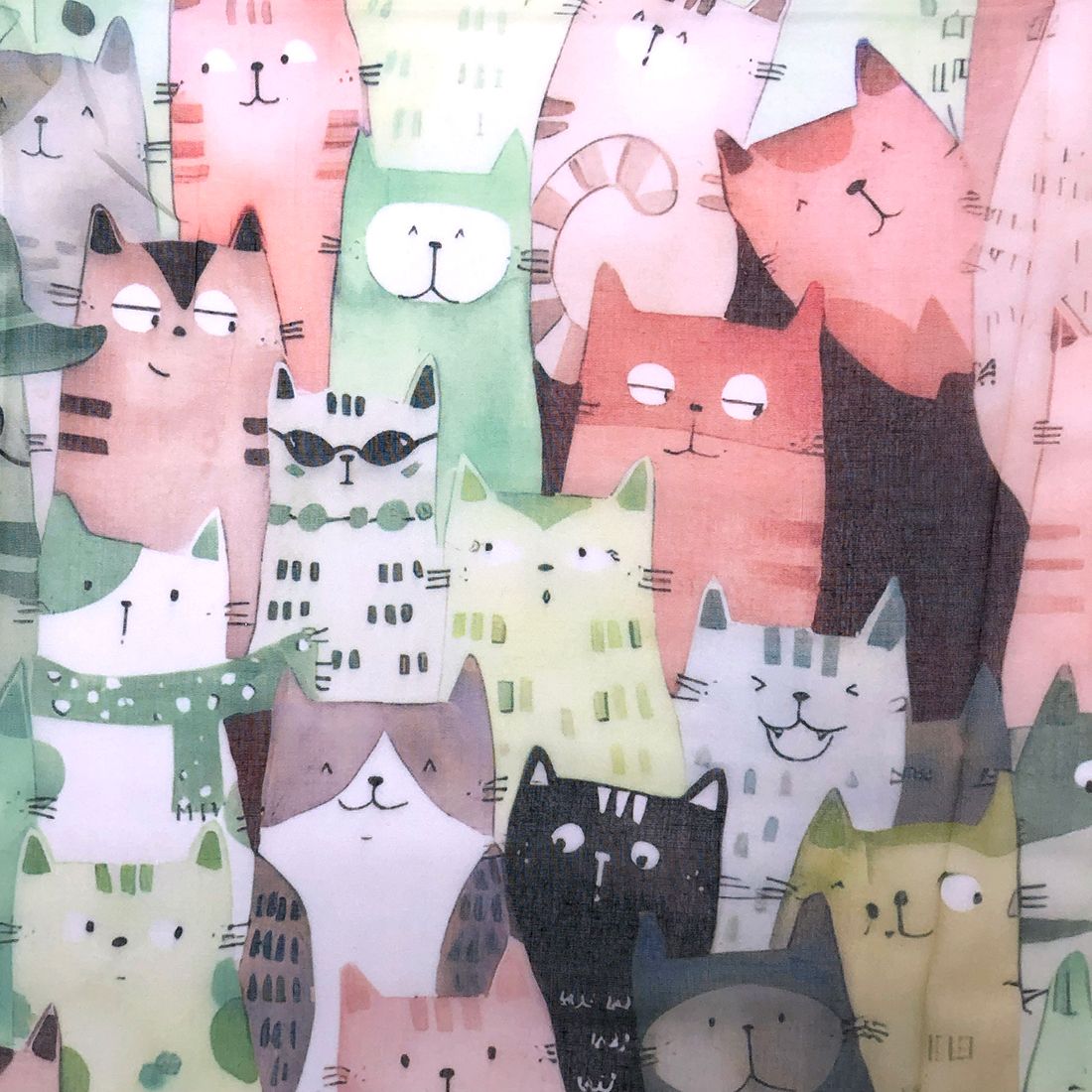 Close-up van de groene chiffon sjaal met kattenprint van een vrolijk patroon van gestileerde katten.