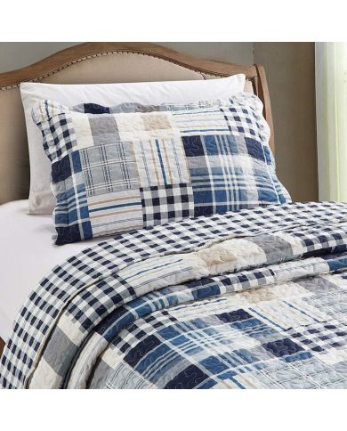 Een blauwe kussensloop met bijpassende sprei op een netjes opgemaakt bed. Een blauwe kussensloop met bijpassende sprei op een netjes opgemaakt bed.