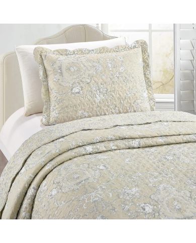 Een beige kussensloop met bijpassende sprei op een knus bed bij het raam. Een beige kussensloop met bijpassende sprei op een knus bed bij het raam.