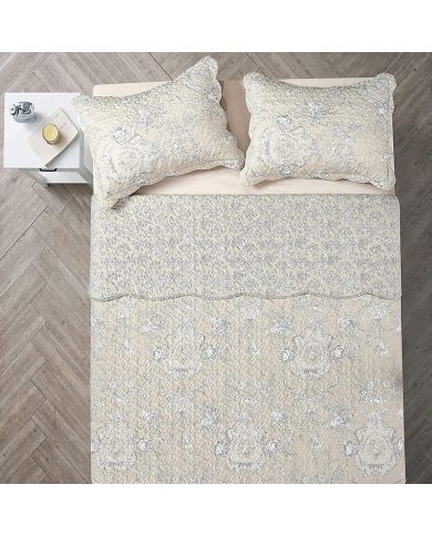Top view of a beige pillowcase on a bed, complemented by a matching Toile quilt.