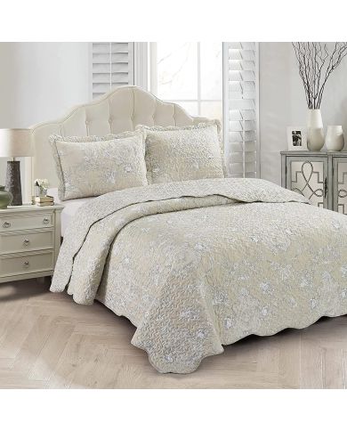 Elegant beige pillowcase with subtle floral print, scalloped edges, and matching quilt on a cosy bed.